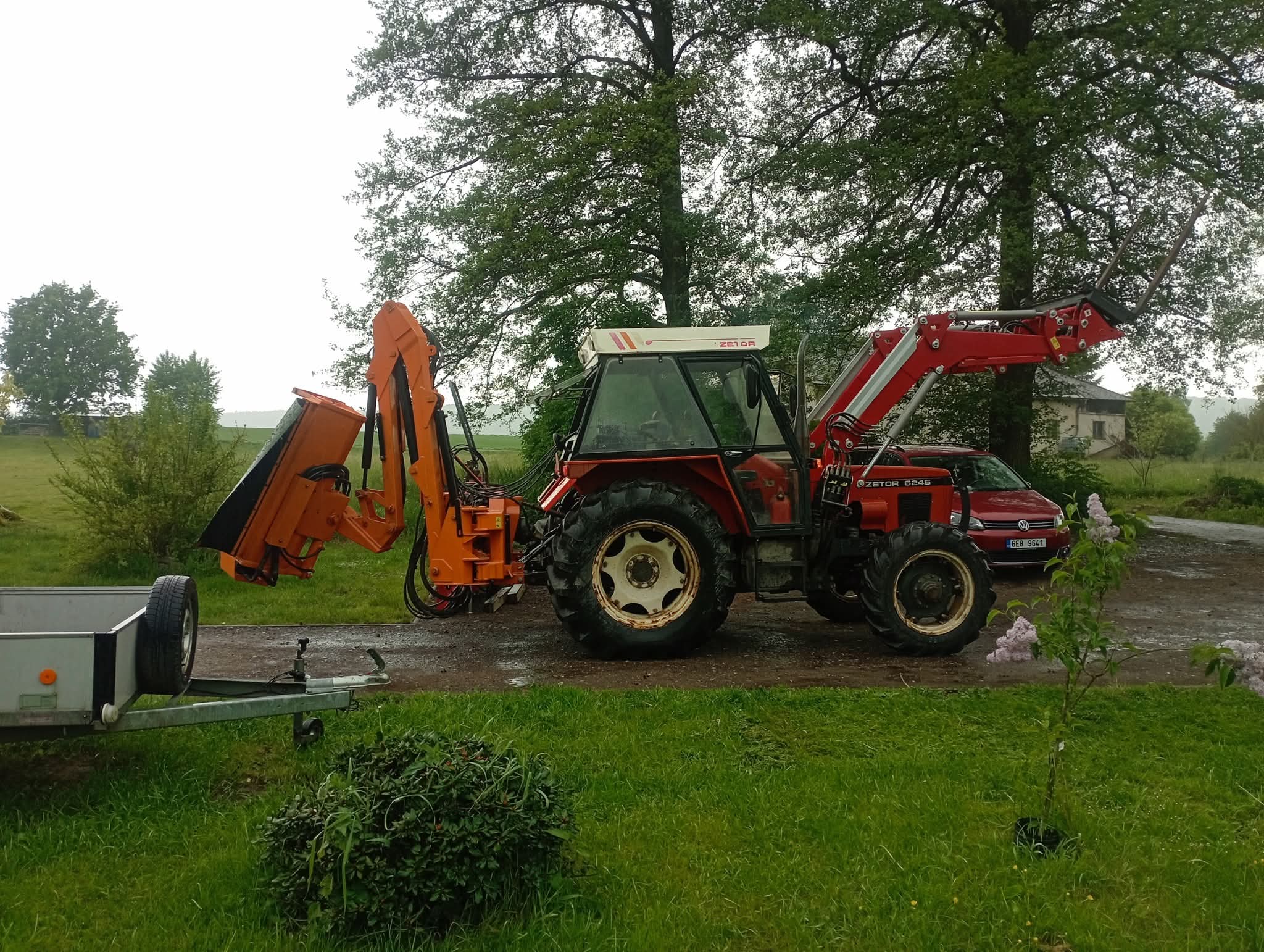 Traktor s mulčovačem při údržbě zarostlého pozemku