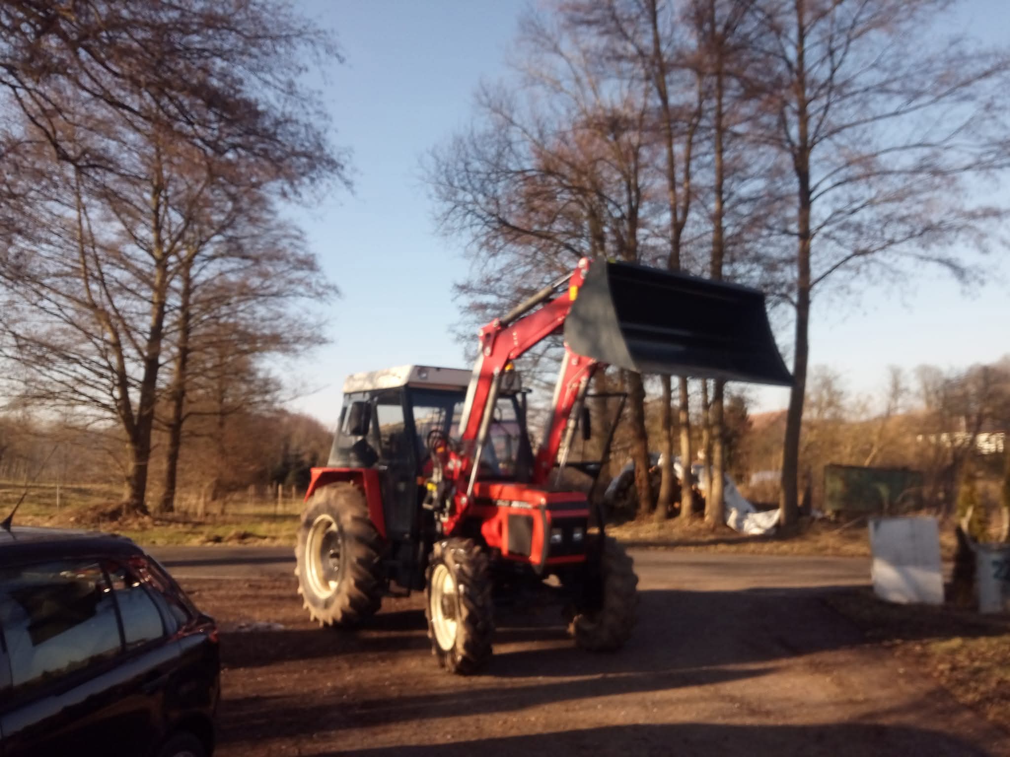 Traktor s čelním nakladačem při manipulaci materiálu